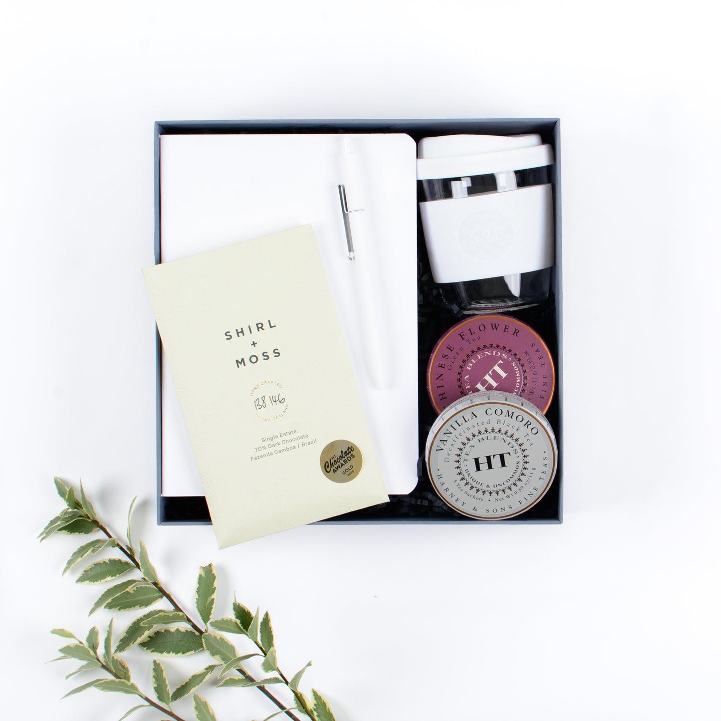 Gift box includes notebook, pen, two teas, chocolate, reusable cup.