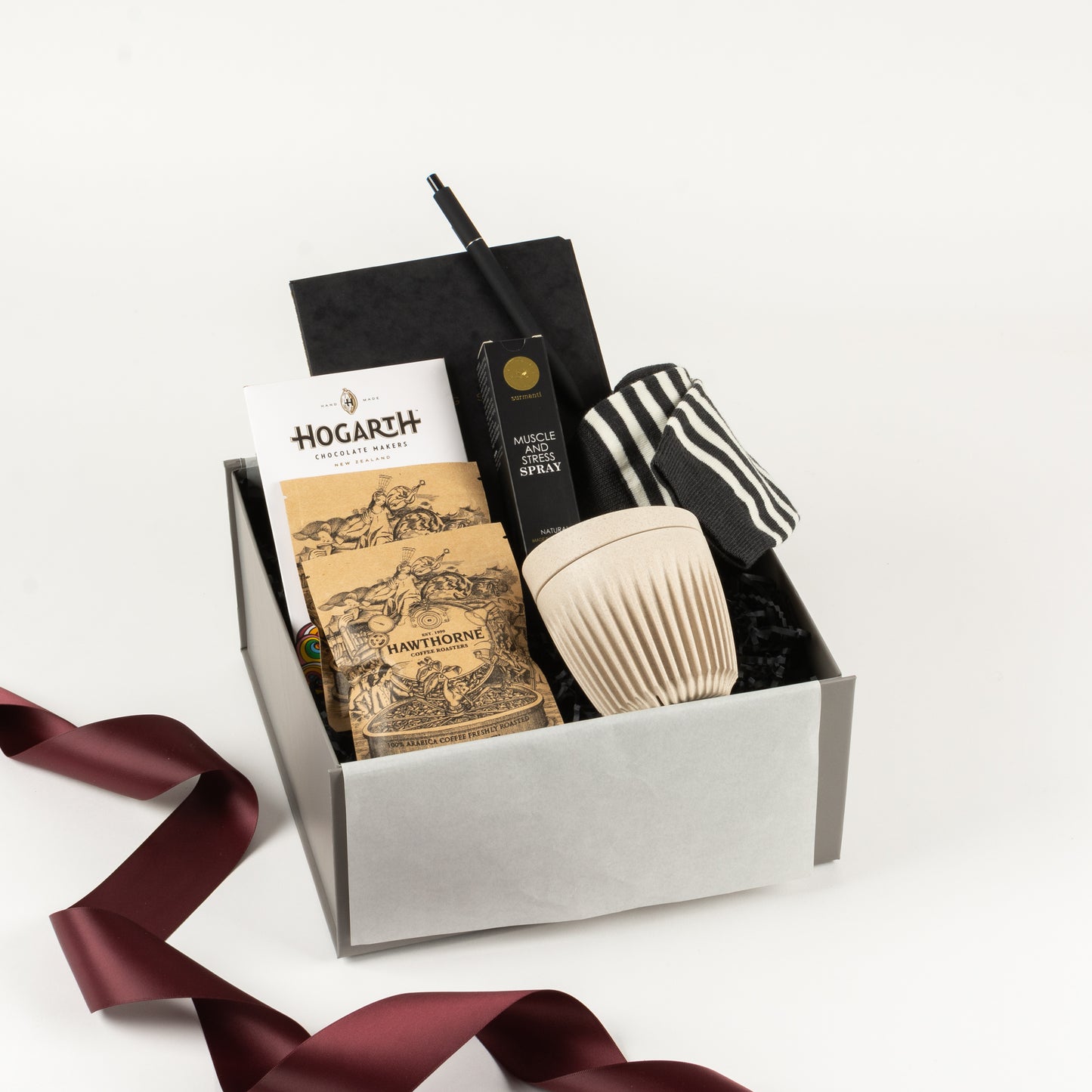 Select Him - Gift Boxes NZ - Gifts of Distinction.Included in this gift box are crew socks by Lamington, notebook with pen, reusable cup, muscle and stress spray by Surmanti, craft chocolate and Hawthorne coffee sachets.