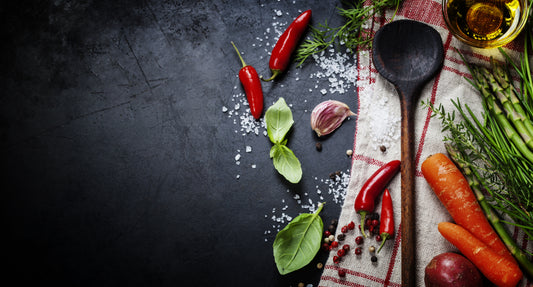 Flatlay photo of cooking utensils and food items. Blog highlights Gourmet and Artisan gifts. 