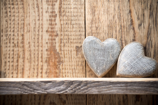 Couple of hearts propped against wooden wall