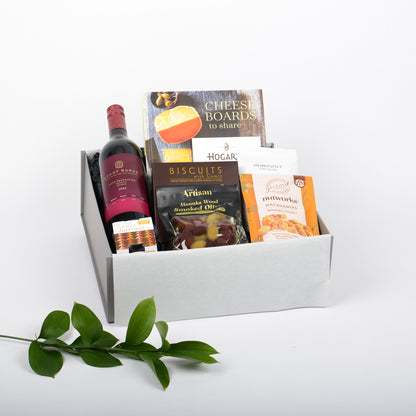 Gift box with wine, cheese board book and snacks on a white background
