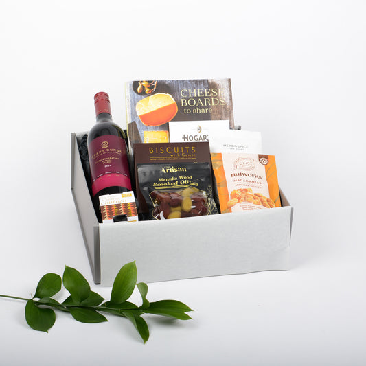 Gift box with wine, cheese board book and snacks on a white background