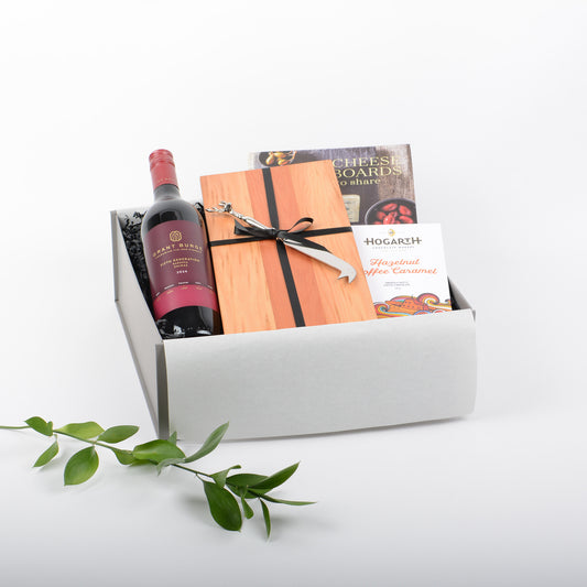 Gift box with wine, artisan cheese board, cheese knife, chocolate and book.