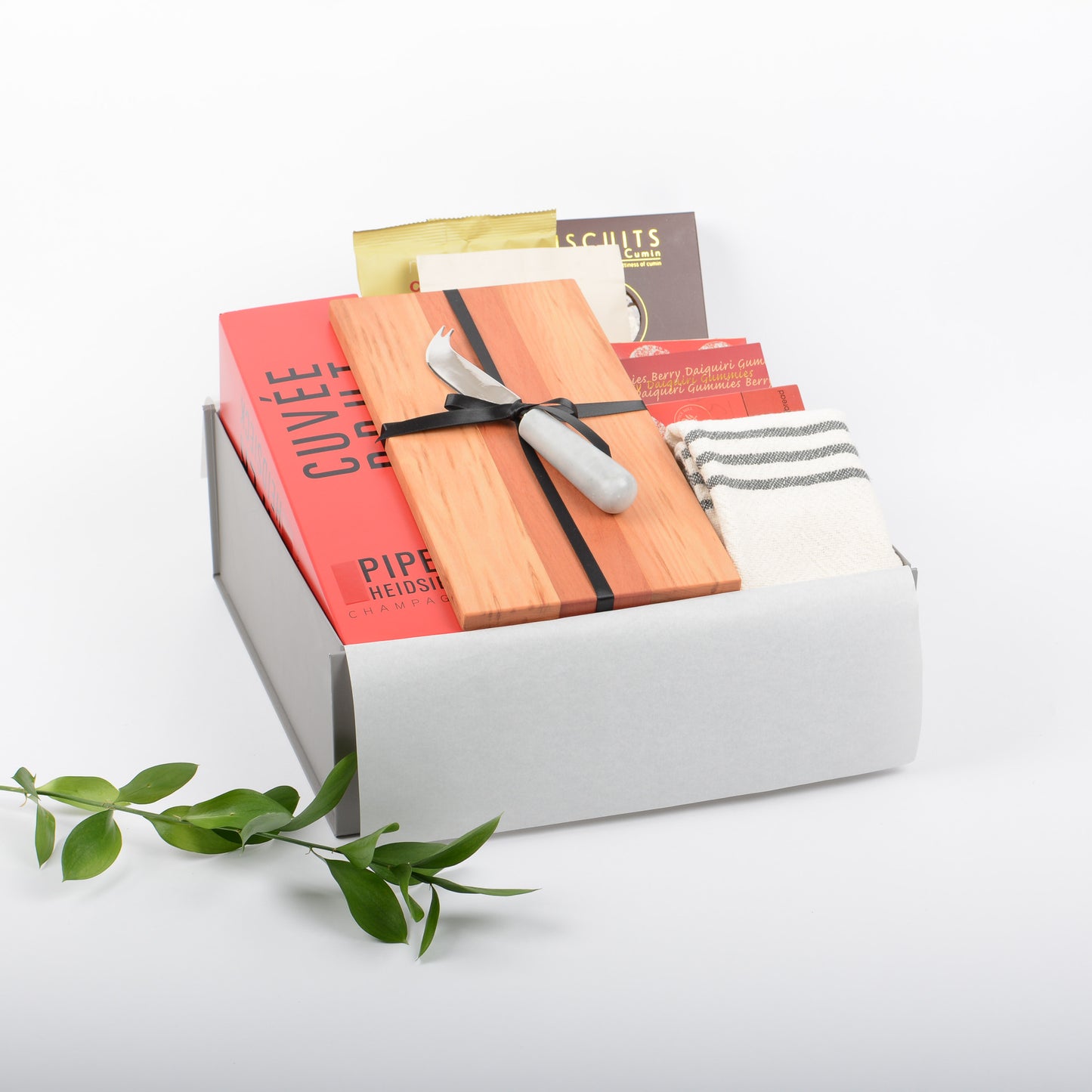 A gift box filled with treats, french champagne, artisan board and cheese knife.