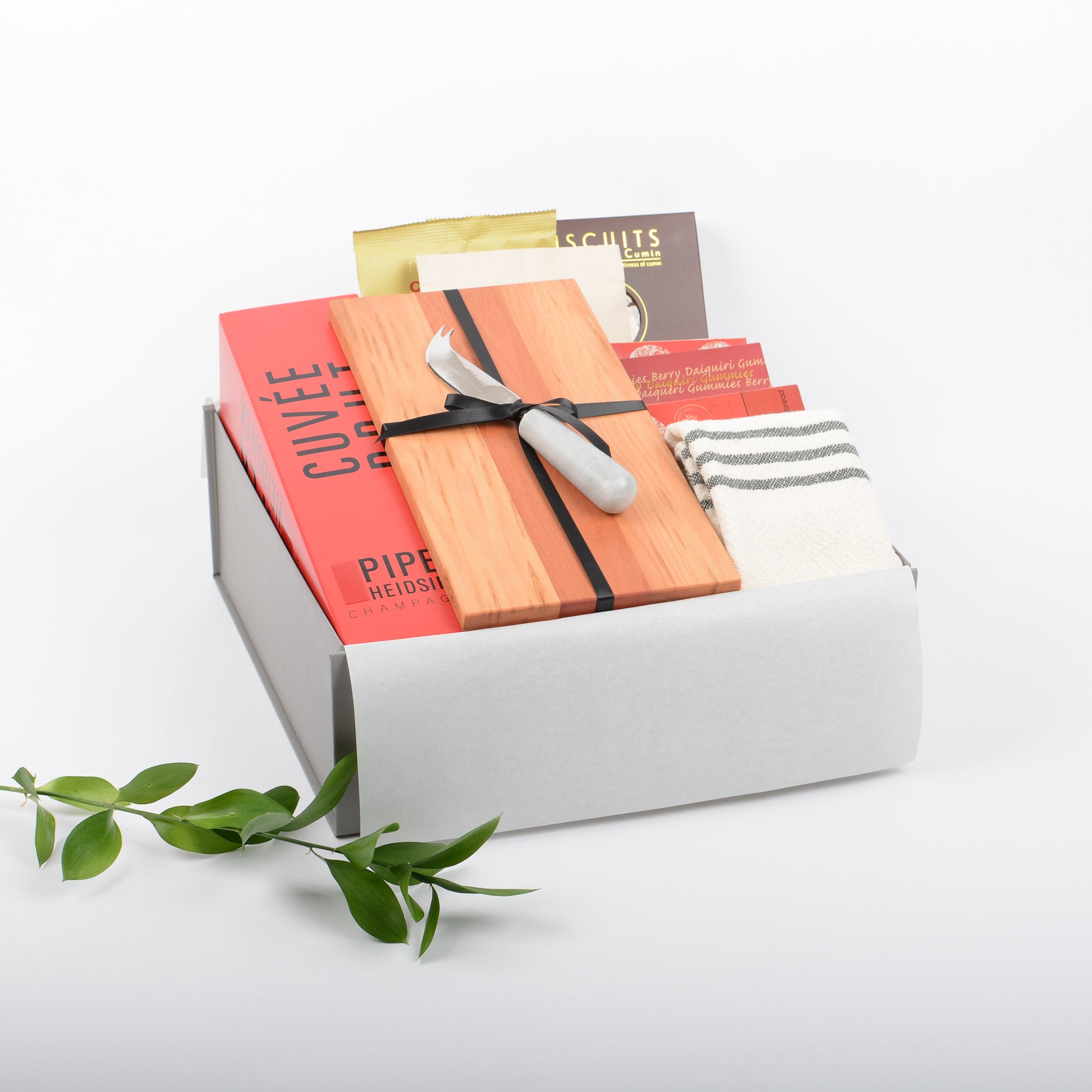 A gift box filled with treats, french champagne, artisan board and cheese knife.