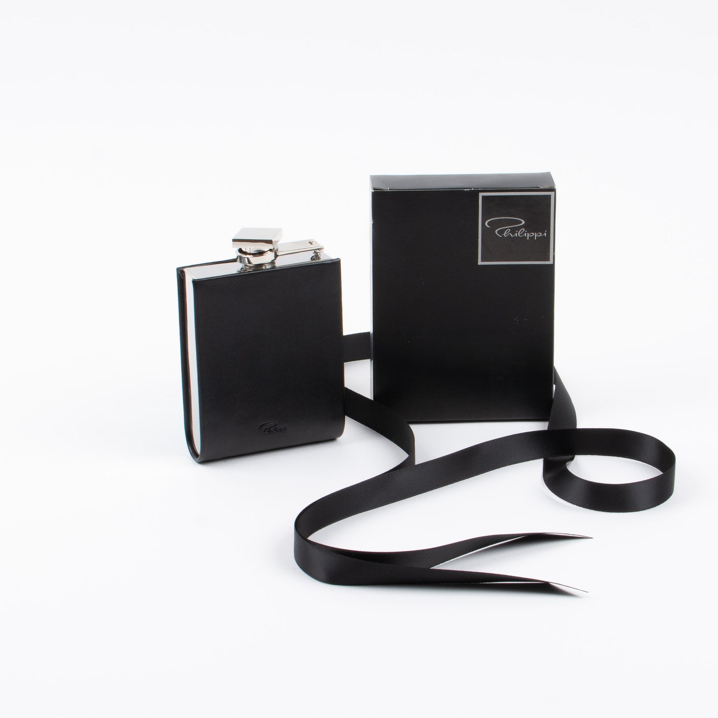 A black leather hip flask with a swivel bracket fastener, displayed alongside its black box packaging, on a white background.