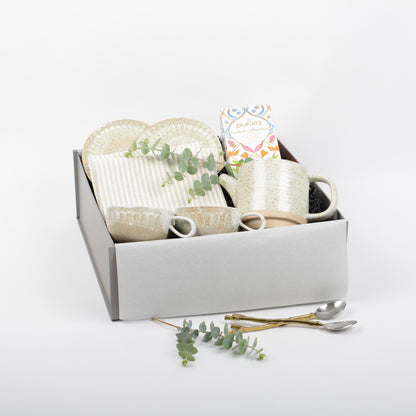 Set of ceramic tea cups, saucers and matching tea pot. Linen napkins and herbal tea are included in a gift box.