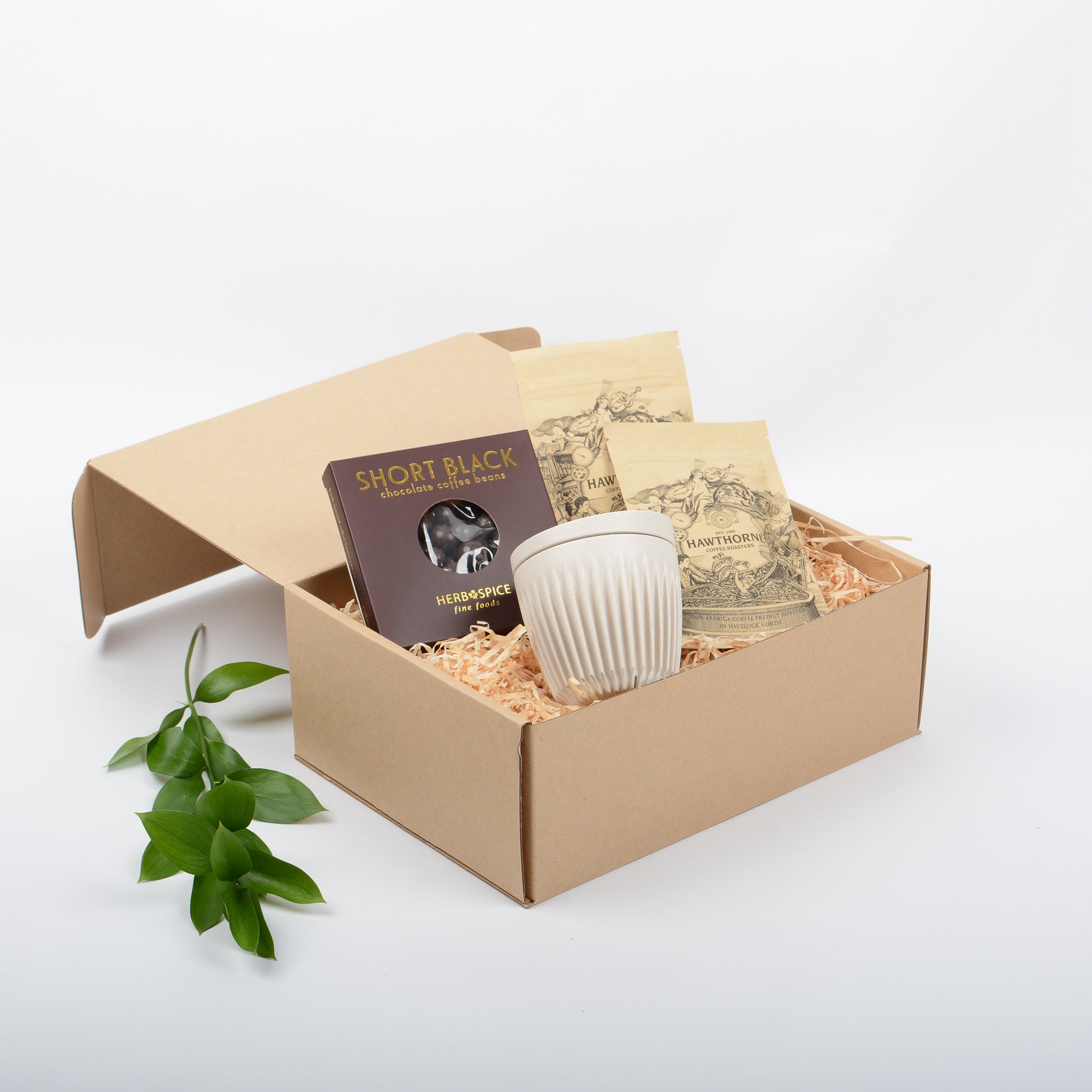 A gift box with coffee, eco cup and coffee chocolate treats.