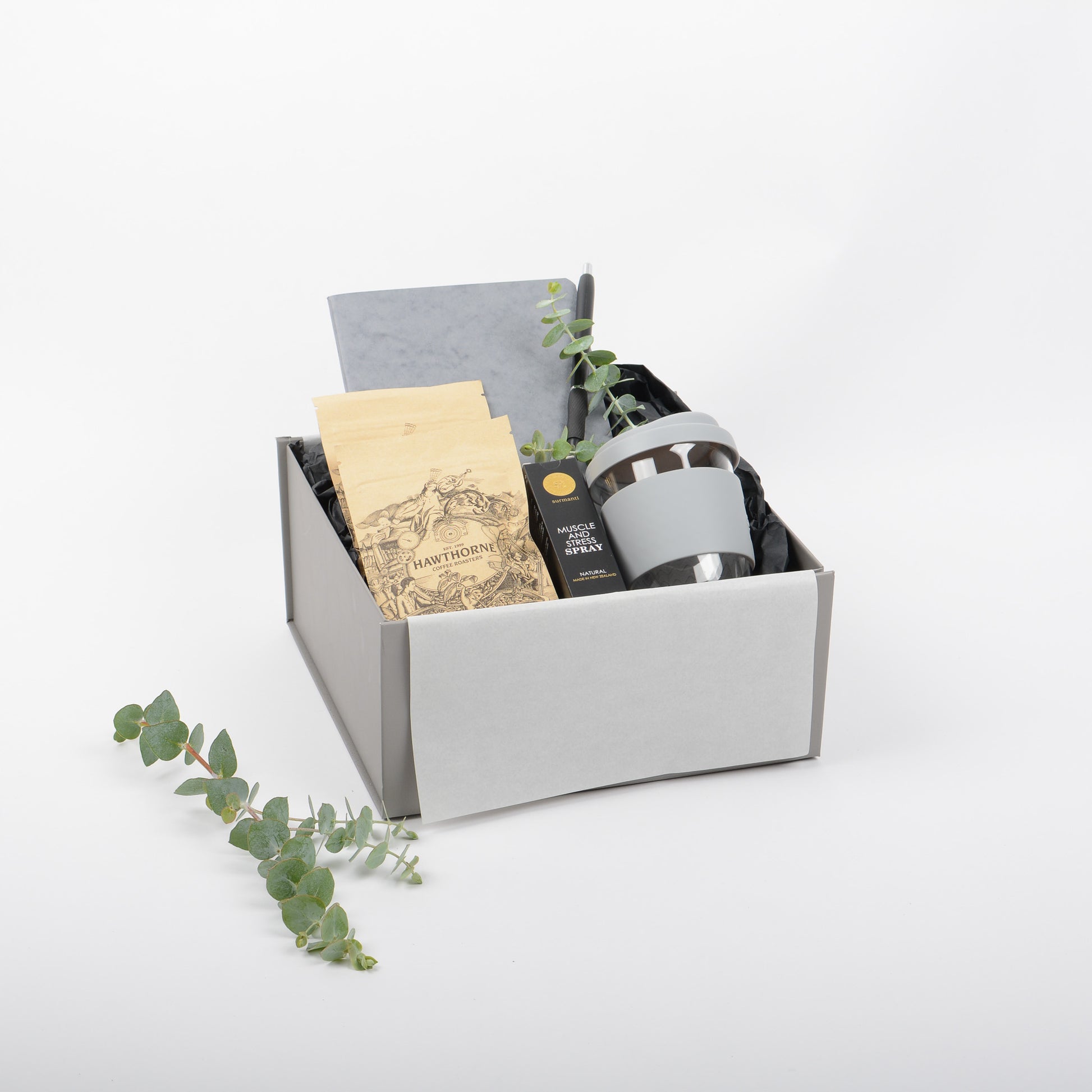 Gift box with stationery items, stress spray and reusable cup.