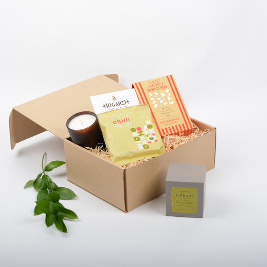 Featuring gourmet  popcorn, candle, chocolate, nuts in a kraft gift box.