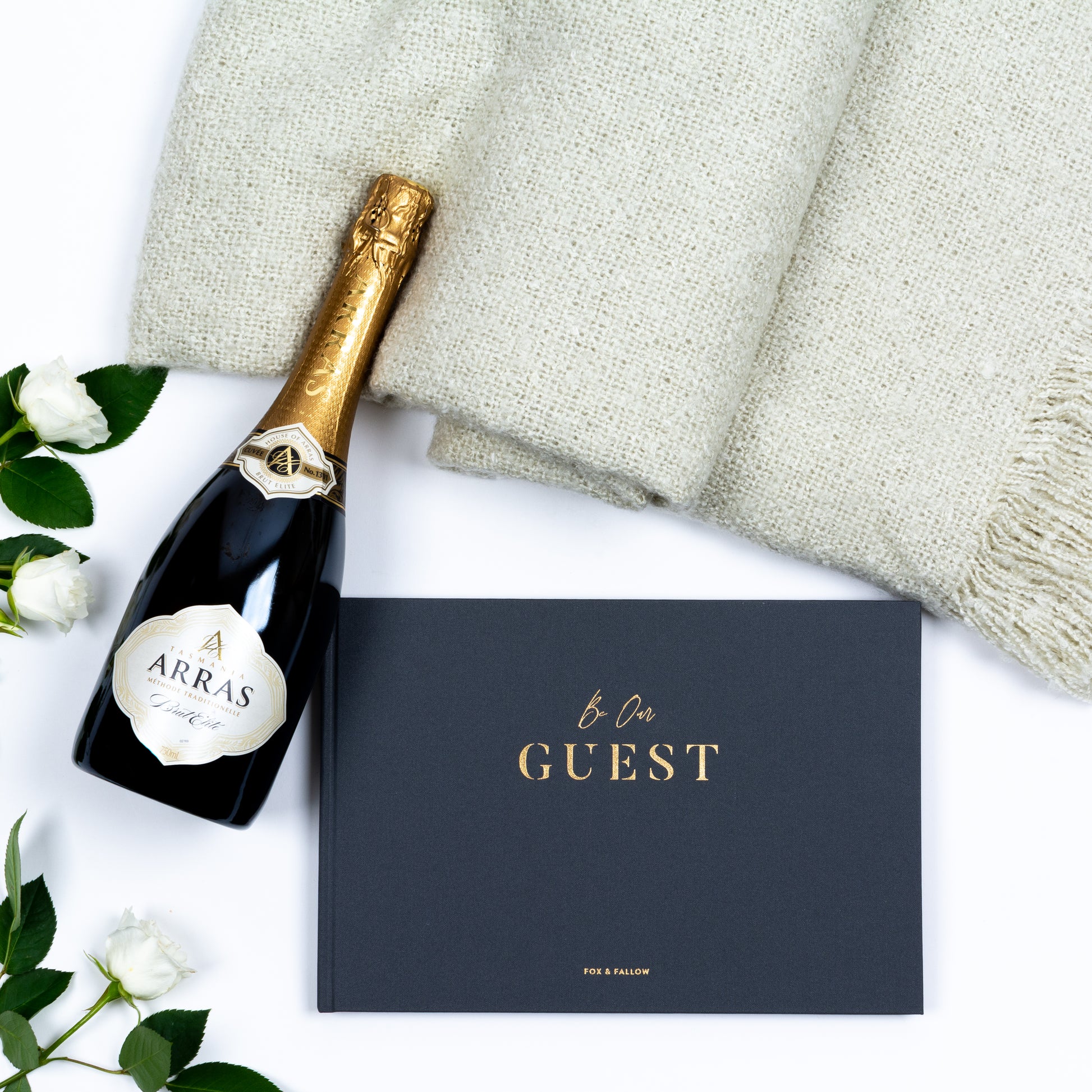 Products featured out of gift box are brut cuvee, guest book, soft throw.