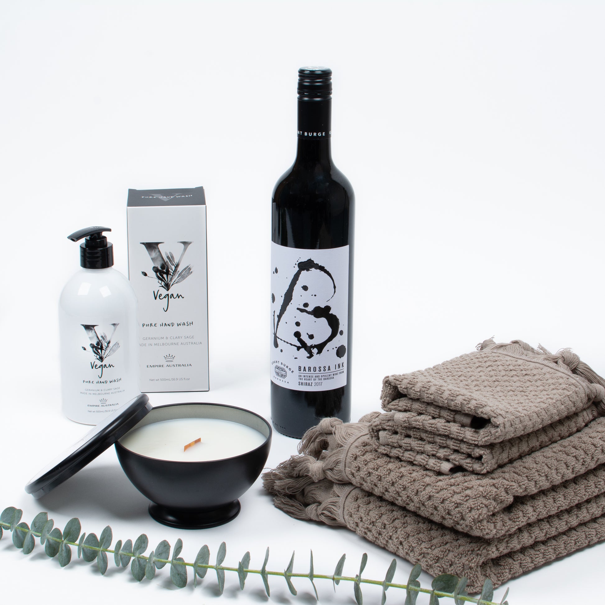 Products featured out of gift box are hand towels, facecloths, red wine, candle, hand wash.