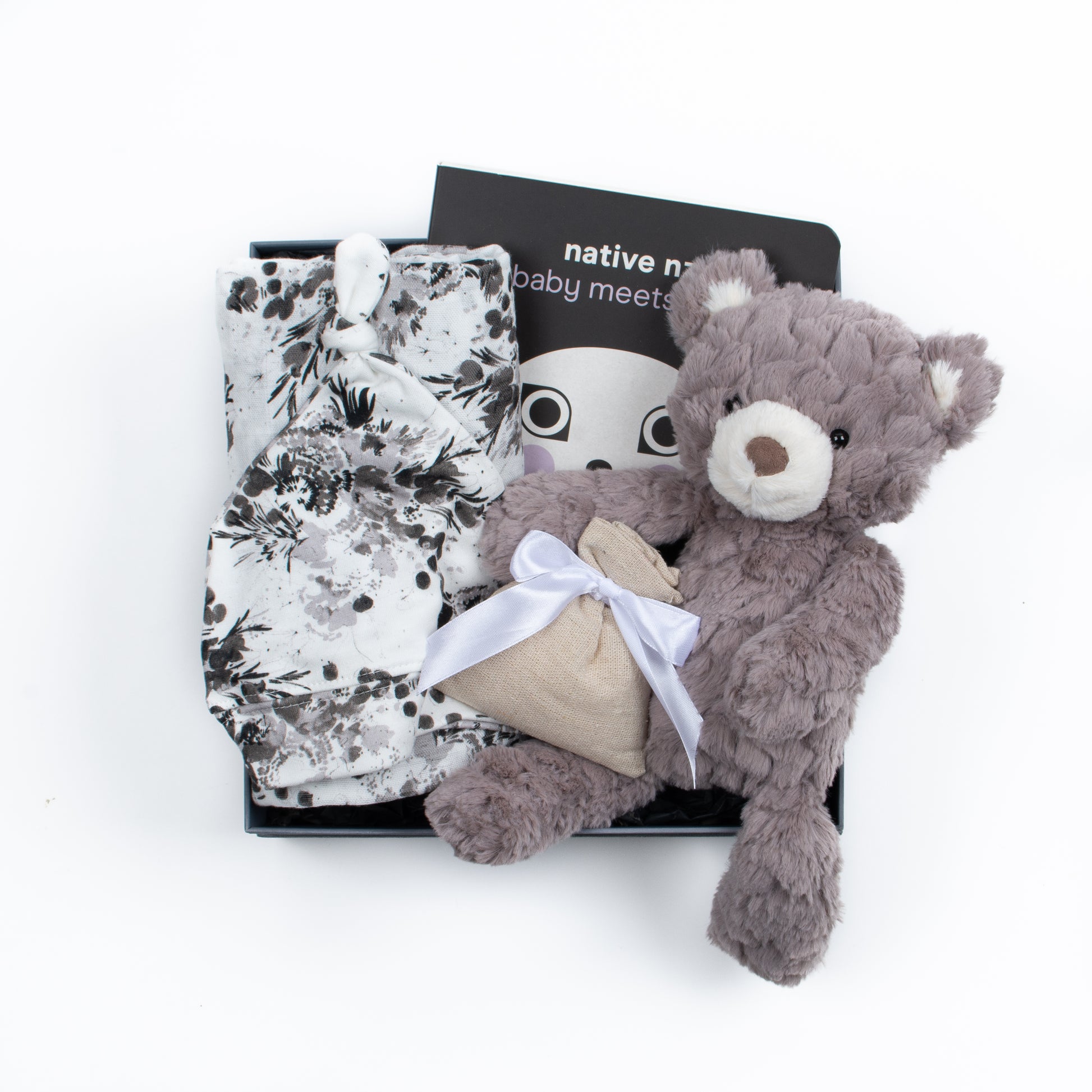 Gift box features swaddle and knot hat, soft toy, book, lavender pouch.