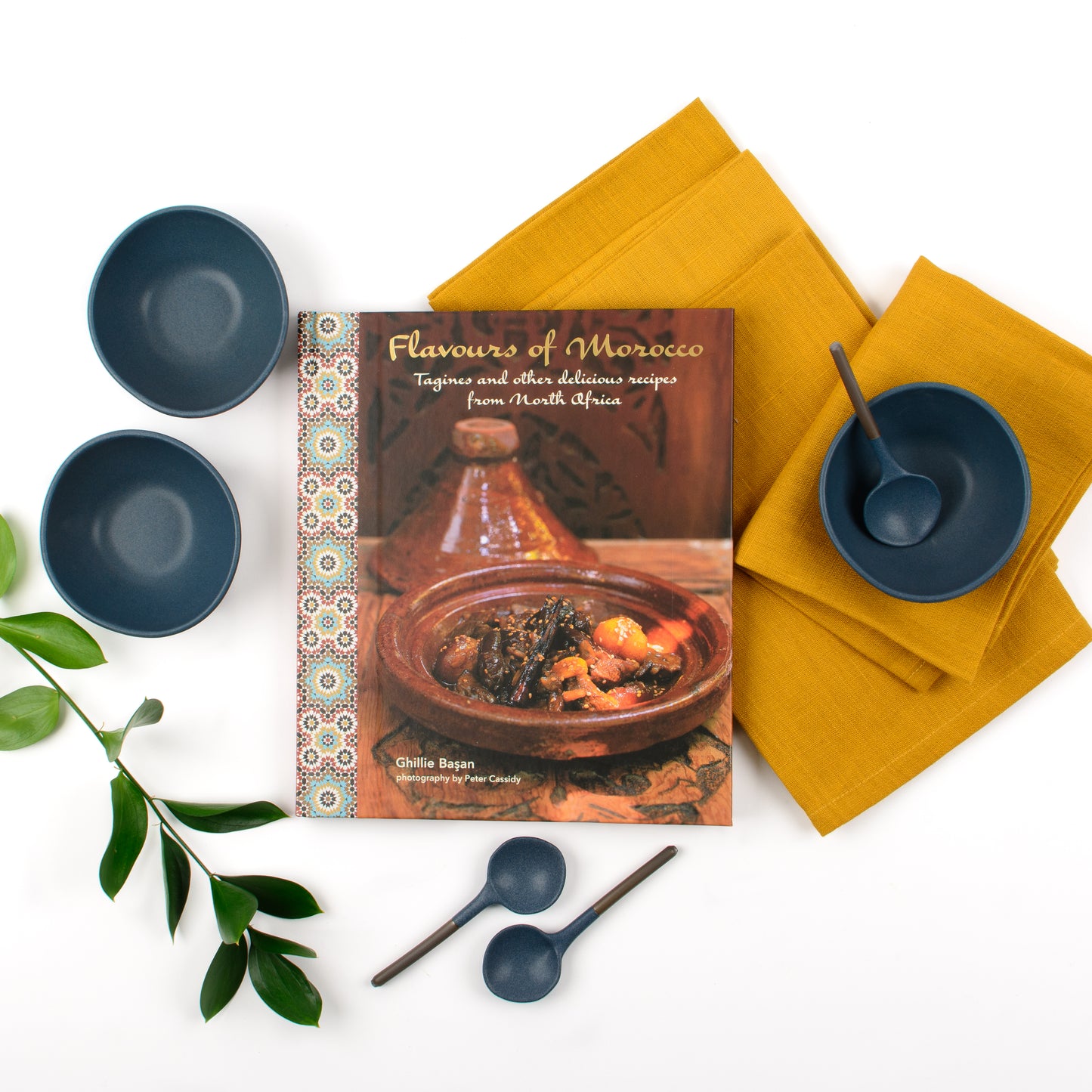 Products displayed out of gift box featuring cookbook, set of linen napkins, three ceramic bowls and matching spoons