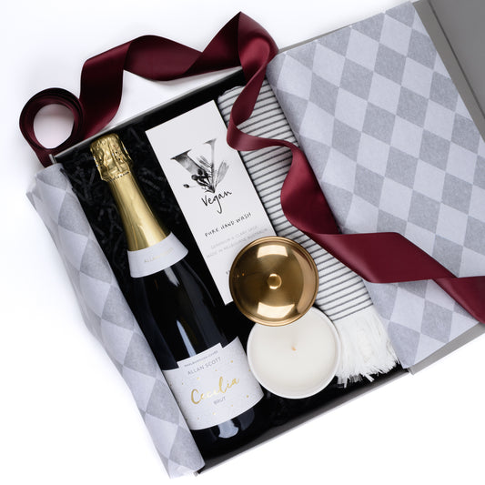 Gift box contains sparkling wine, hand wash, scented candle, hand towel.