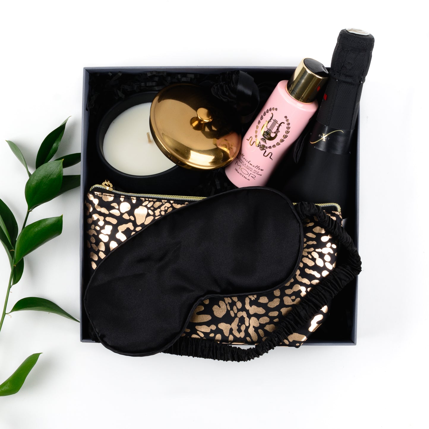 Gift box contains cosmetic purse, lotion, candle, eye mask, freixenet.