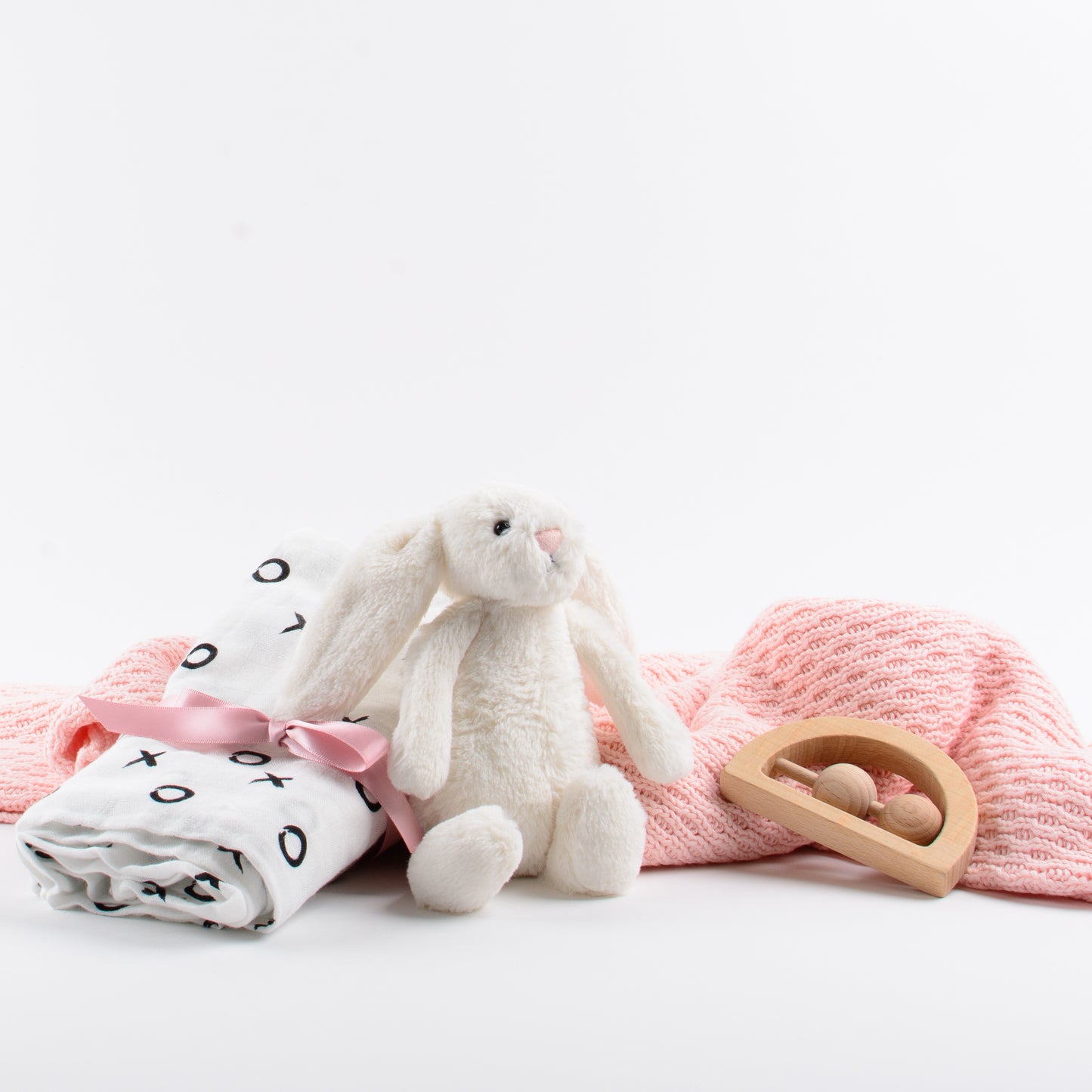 Products shown out of gift box are soft toy, swaddle, blanket, teether.