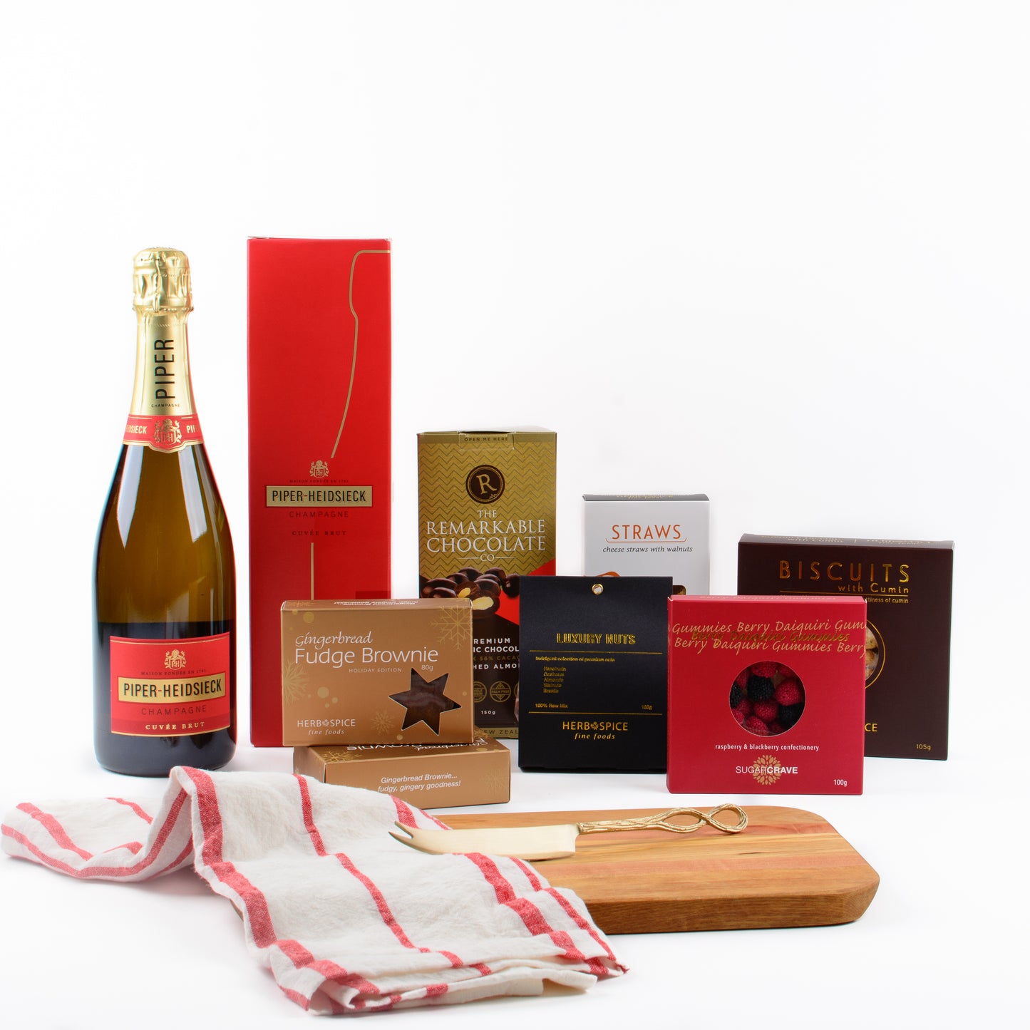 Products displayed out of gift box are champagne, chocolate almonds, savoury biscuits, brownies, candy, nuts, wooden board, cheese knife, linen tea towel.