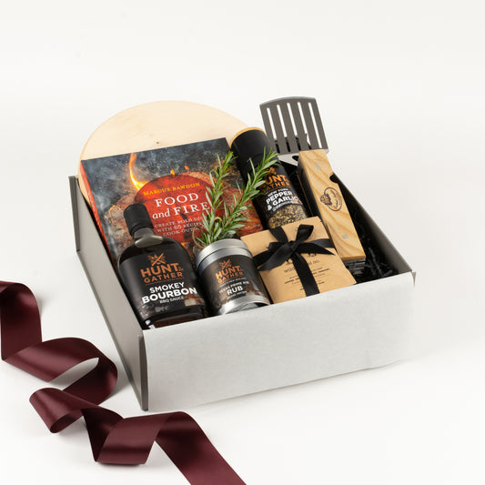 Gift box includes maple wooden board, BBQ cookbook, BBQ multi tool, spices and BBQ sauce. 
