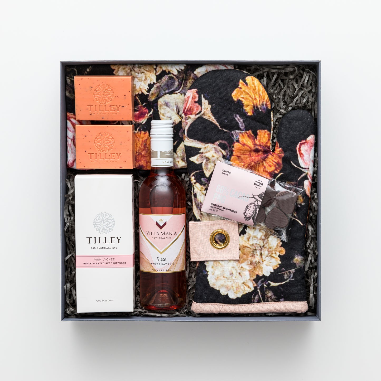 Gift box includes rose wine, chocolate, oven mitt, tea towel, diffuser, two soaps.