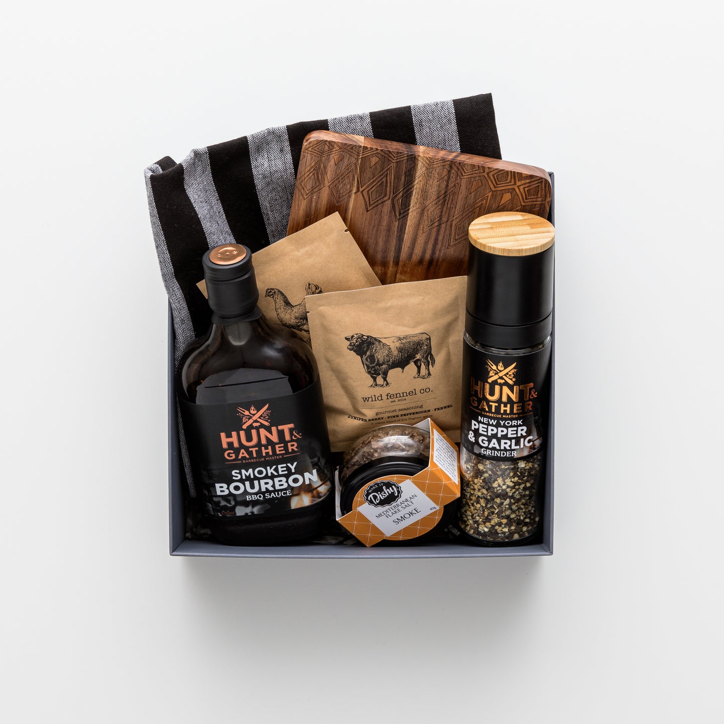 Gift box contains wooden board, pepper grinder, salt, seasoning, bourbon sauce, tea towel.