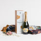 Products featured out of gift box are luxury throw, champagne.