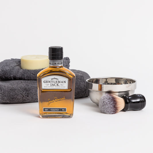 Products displayed out of gift box are whisky, shaving dish and brush, soap, hand towel and face cloth.