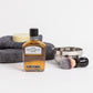 Products displayed out of gift box are whisky, shaving dish and brush, soap, hand towel and face cloth.