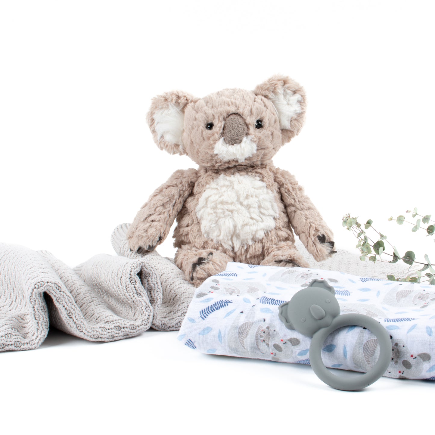 Out of Gift Box products shown are Putty Koala Bear, cotton swaddle and Blanket and silicone teether by Mushie.