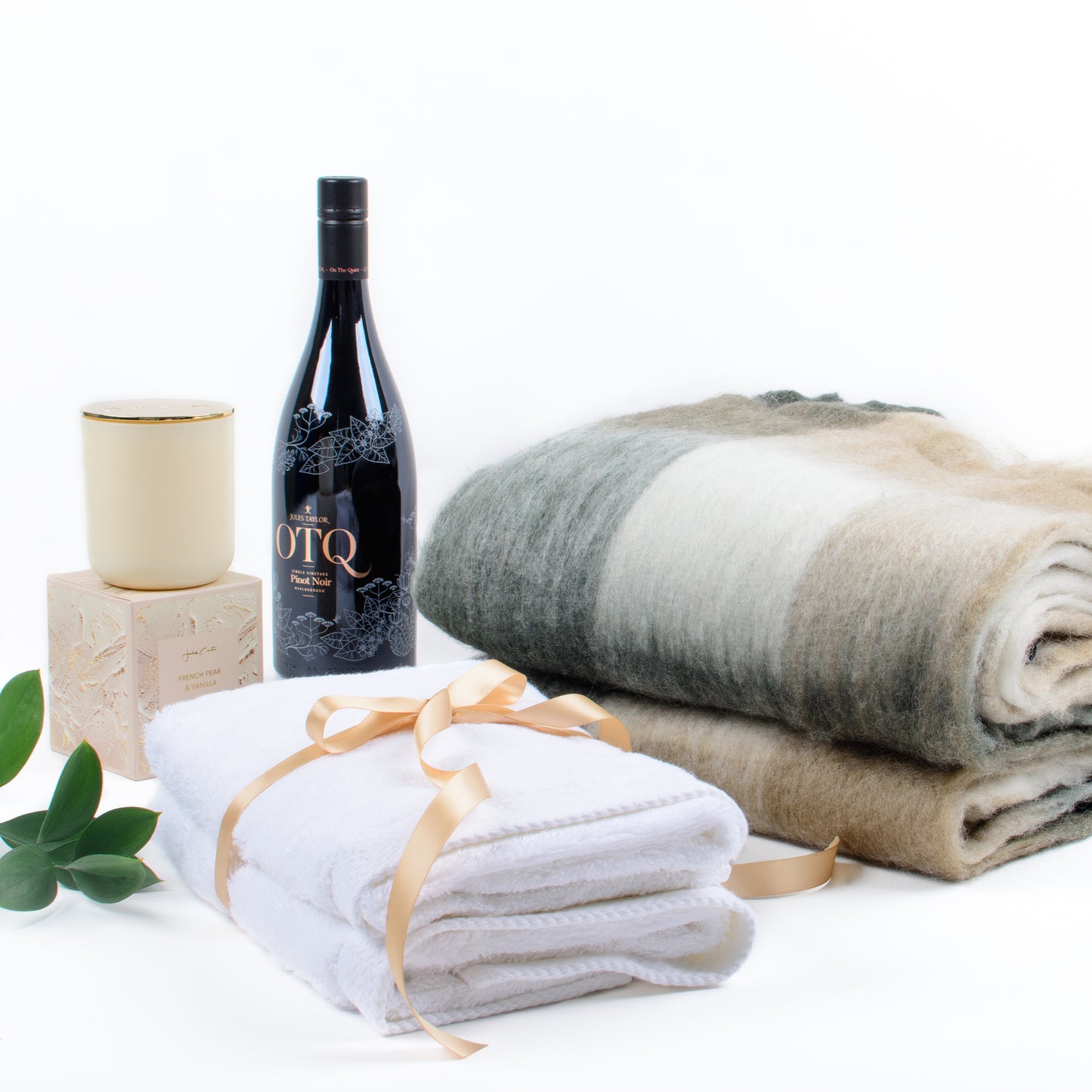 Products featured out of gift box are soft throw, red wine, two hand towels, scented candle.
