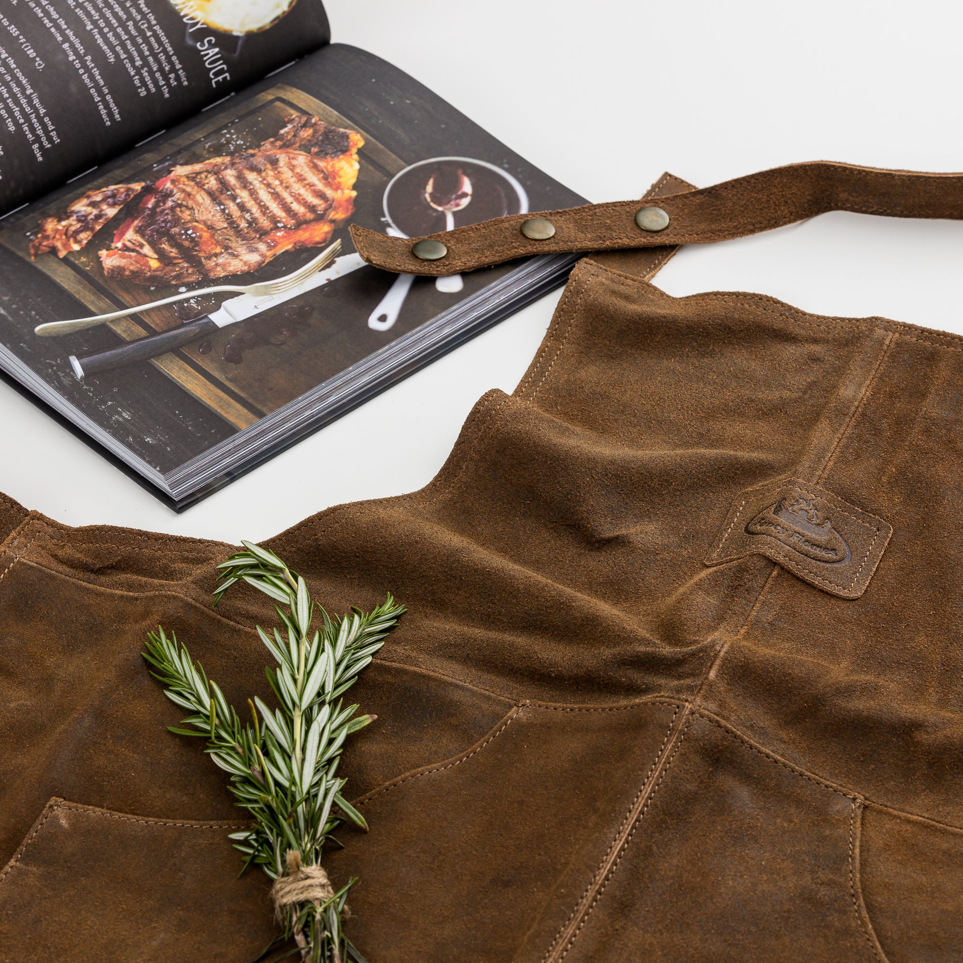 leather BBQ apron and cookbook outside of gift box.