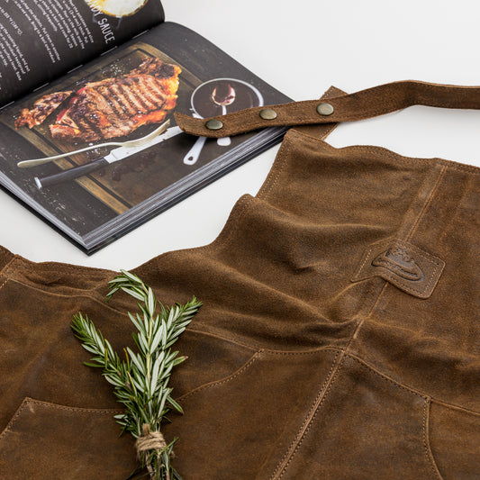 leather BBQ apron and cookbook outside of gift box.