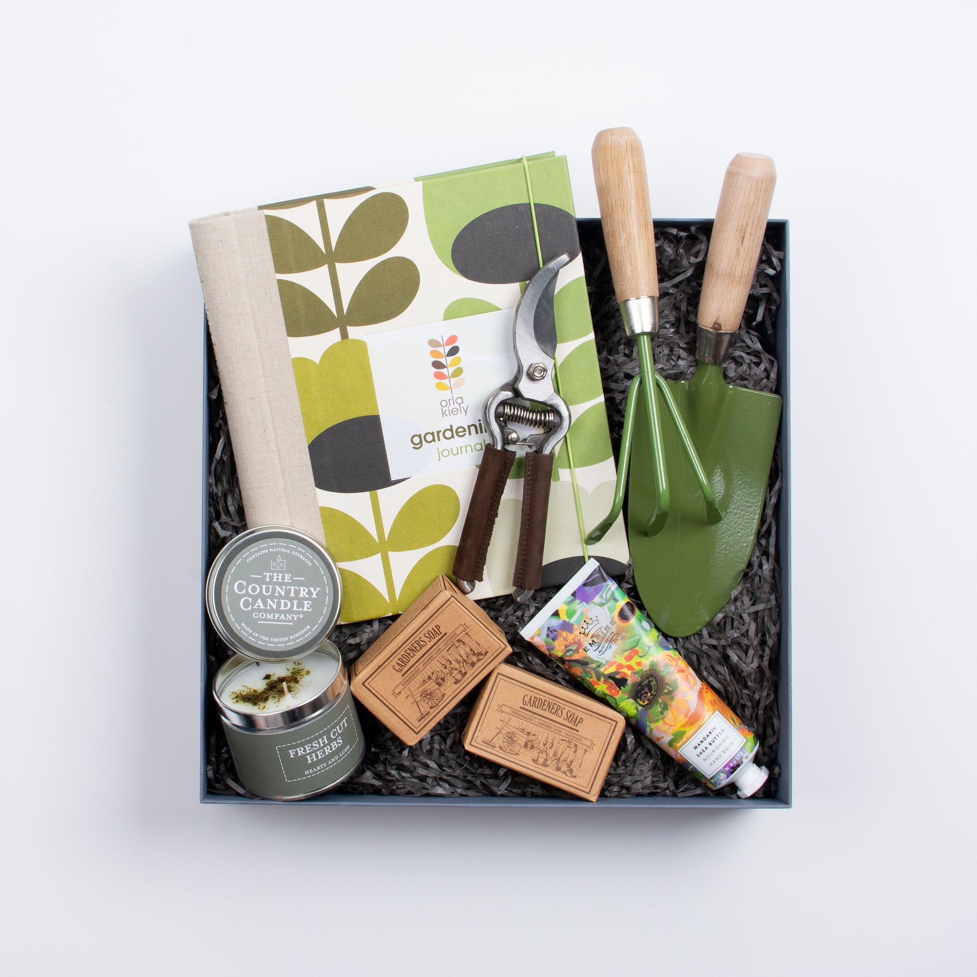 Gift box contains book, gardening fork and spade, two soaps, candle, hand cream, pruner.