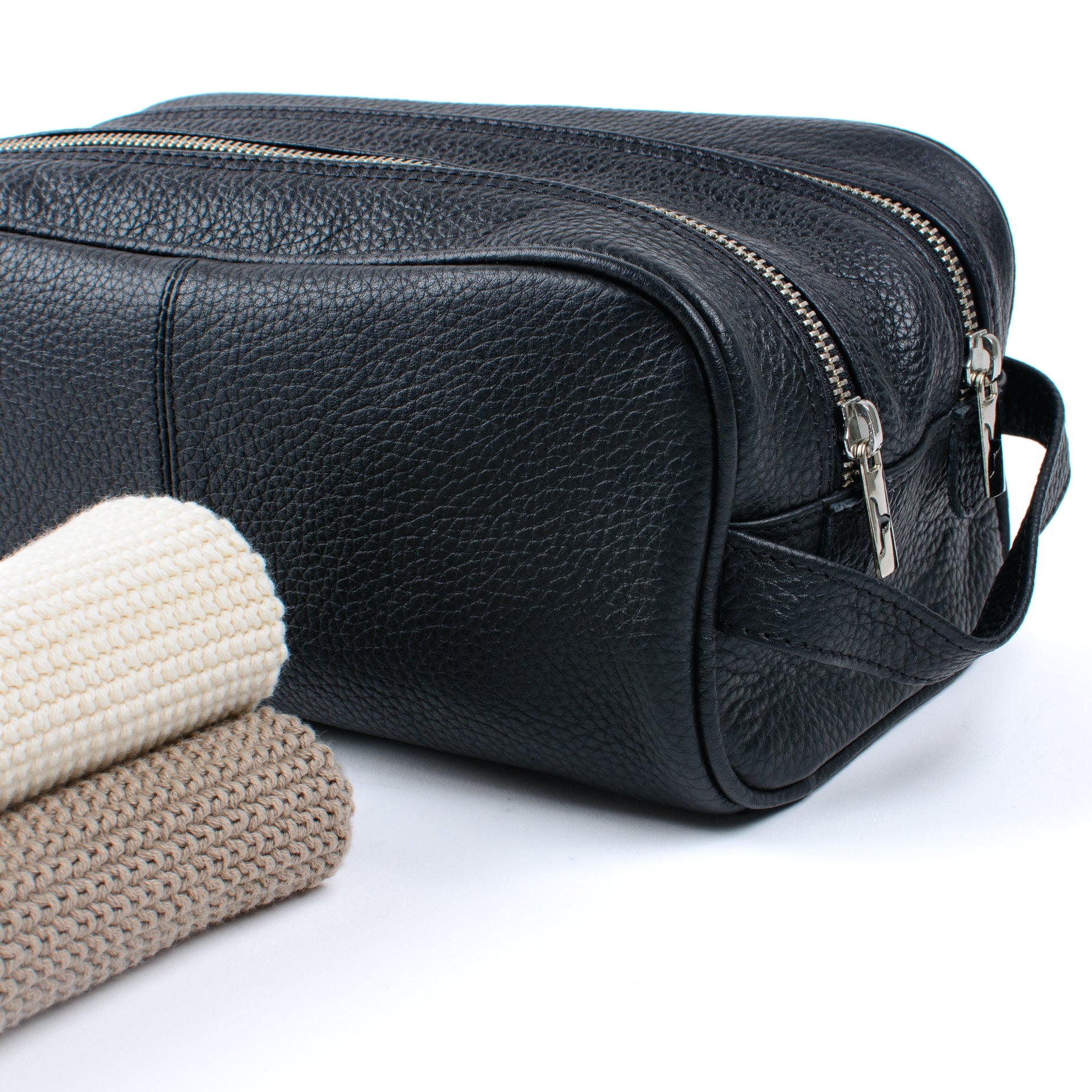Close up of full grain leather washbag and cotton cloths.