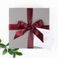 Elegant grey gift box with satin ribbon tied in bow.  Gold foil message card.