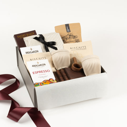 Coffee Break Deluxe - Gift Boxes NZ - Gifts of Distinction. Featured in this gift box are linen napkins, boutique style coffee by Hawthorne, huskee reusable cups, walnut coasters and coffee spoon, sweet treats and Hogarth chocolate tablets.