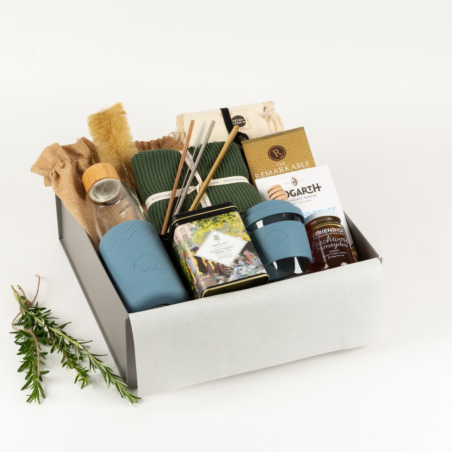 Eco Lovers Deluxe - Gift Boxes NZ - Gifts of Distinction.  Included is a set of organic cotton produce bags, cotton washers, reusable straws, drinking bottle and cup, herbal tea by Harney and sons, craft chocolate treats and artisan honey and dipper.