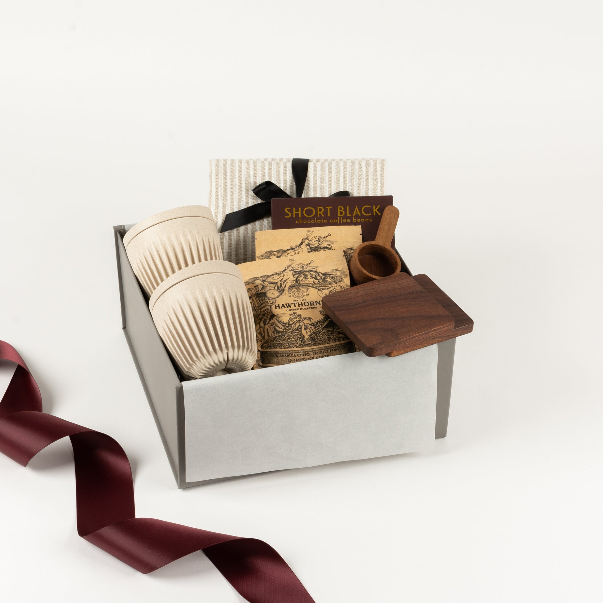 Coffee Break Elite - Gift Boxes NZ - Gifts of Distinction.  This gift box includes linen napkins, 2x huskee reusable cups, Hawthorne coffee sachets and walnut wooden coasters and coffee spoon.