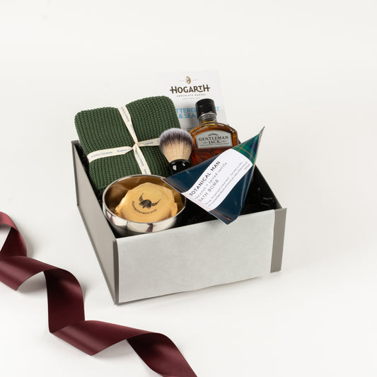Gentleman's Ritual - Gift Boxes NZ - Gifts of Distinction. Featured in this gift box are a set of cotton washers, botanical mans bath bomb, craft chocolate by Hogath, Gentleman Jack whisky, stainless steel dish with soap and shaving brush.